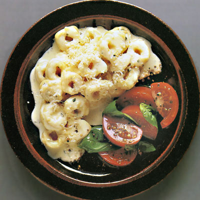 Тортеллини под сырным соусом с салатом из помидоров и базилика.
